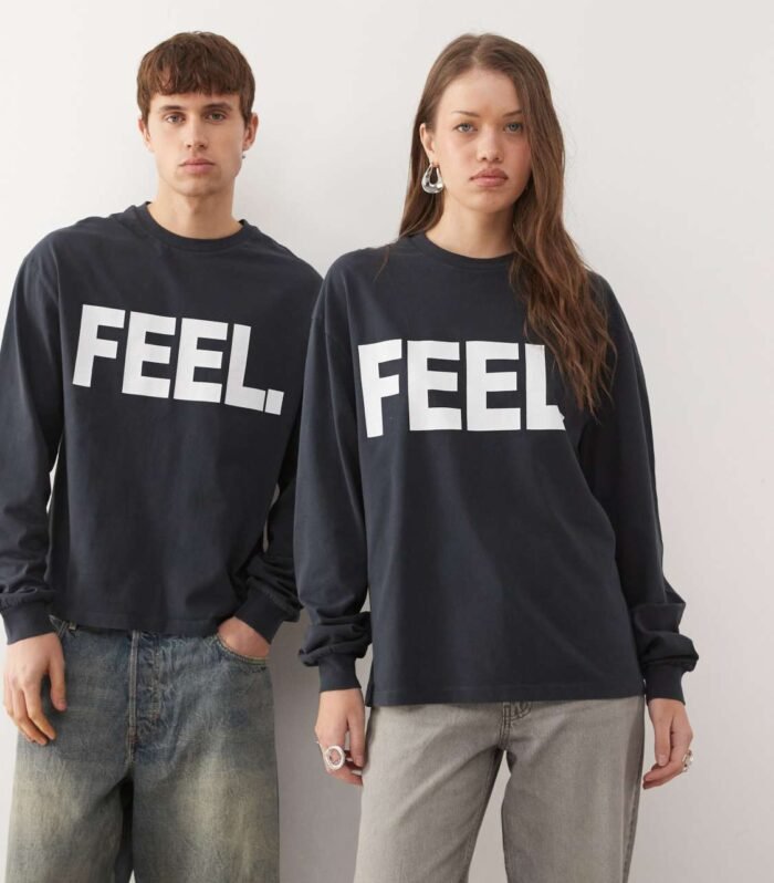 Wearing S COLLUSION Unisex long sleeve boxy t-shirt with 'FEEL' graphic in black